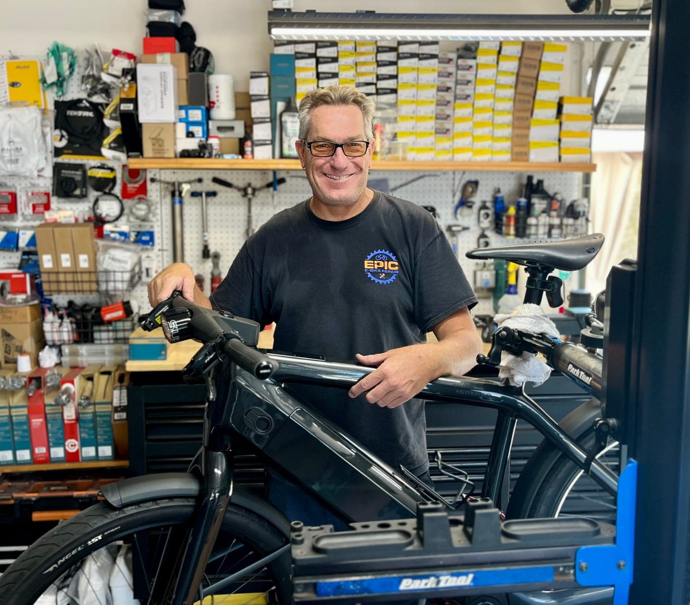 Brooks, owner of Epic E-Bike Repair, in his shop with a Stromer e-bike on the stand